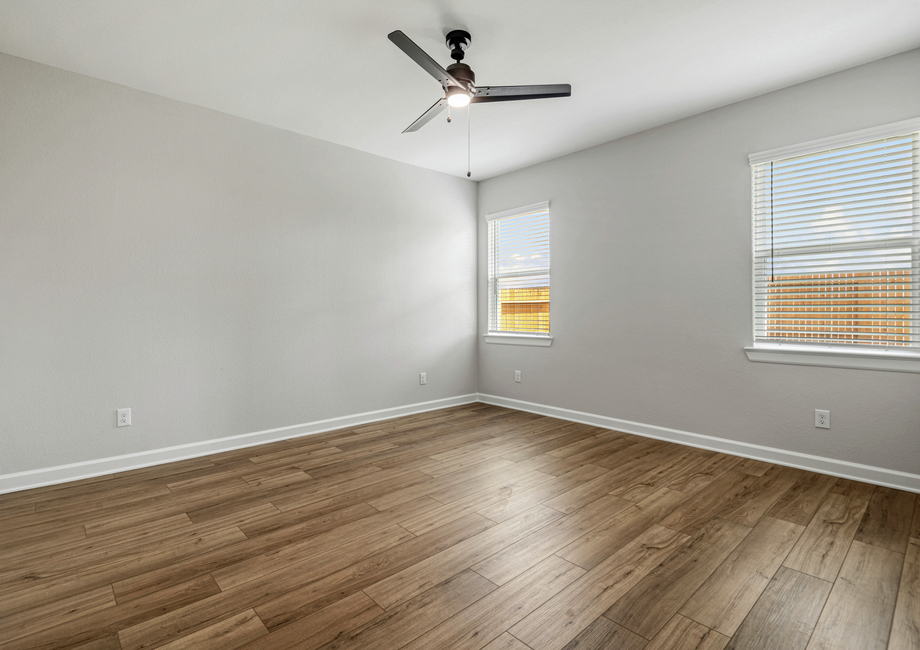 A spacious master bedroom with two windows