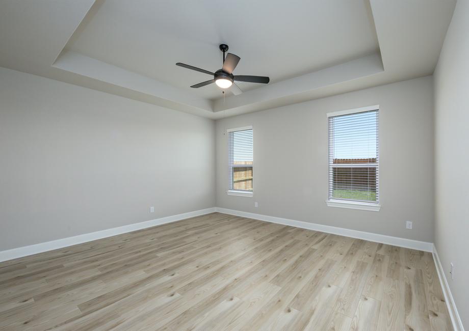 The master bedroom has a ceiling fan and luxury vinyl plank flooring.