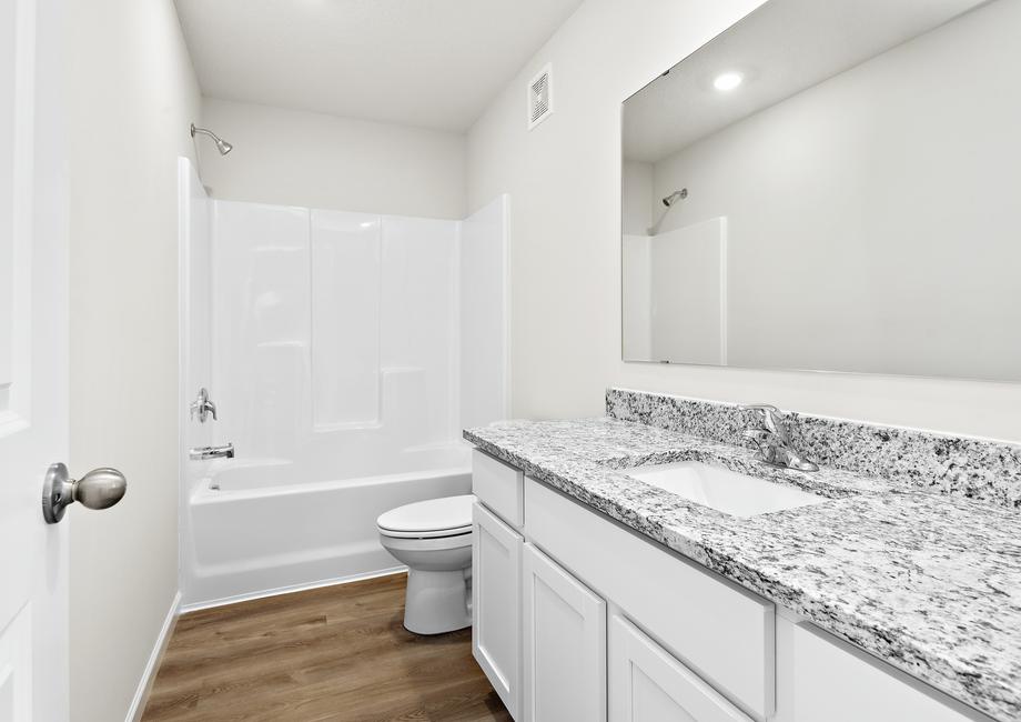 The secondary bathroom has a large vanity and tub/shower combo.