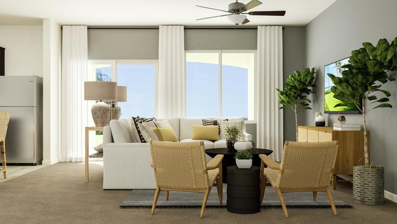 Rendering of the living area featuring a
  large section, accent chairs, decorative furniture, and a view of the covered
  patio in the background.