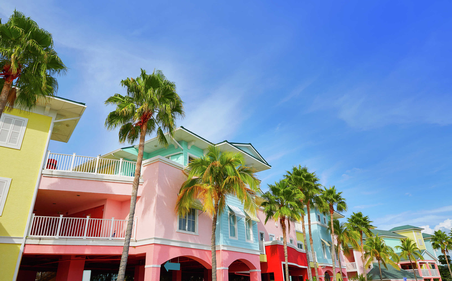Fort Myers, Florida row of multi-colored homes including baby blue, yellow, pink, and red that are lined with palm trees