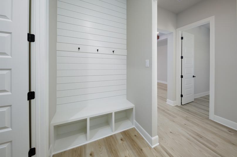 The mudroom has a built-in storage bench with shiplap details.