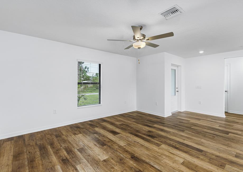 A spacious family room with a window facing the front of the house.