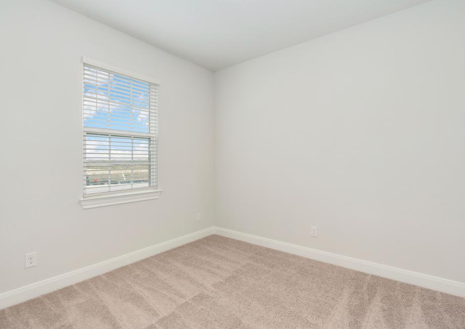 Guest bedroom with recessed lighting and a window to create a bright space.