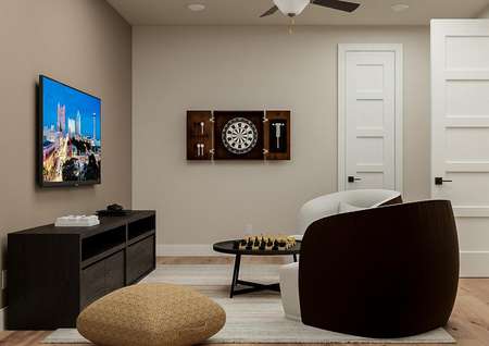 Rendering of the media room showing a
  media cabinet with tv left, a dartboard centered on the wall, and two
  matching chairs with table on the right. 