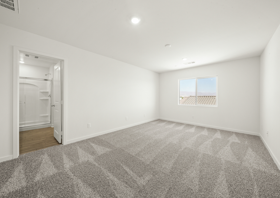 The master bedroom has a large window and carpet.