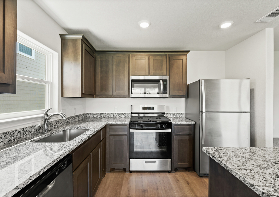 The upgraded kitchen has sprawling granite countertops.