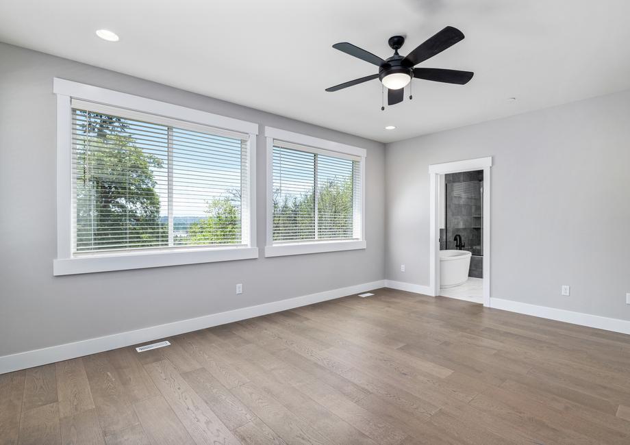 The master bedroom has wood flooring, tons of windows and a private living area.