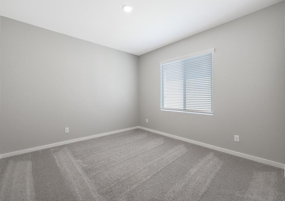 Guest bedroom with windows and recessed lighting.