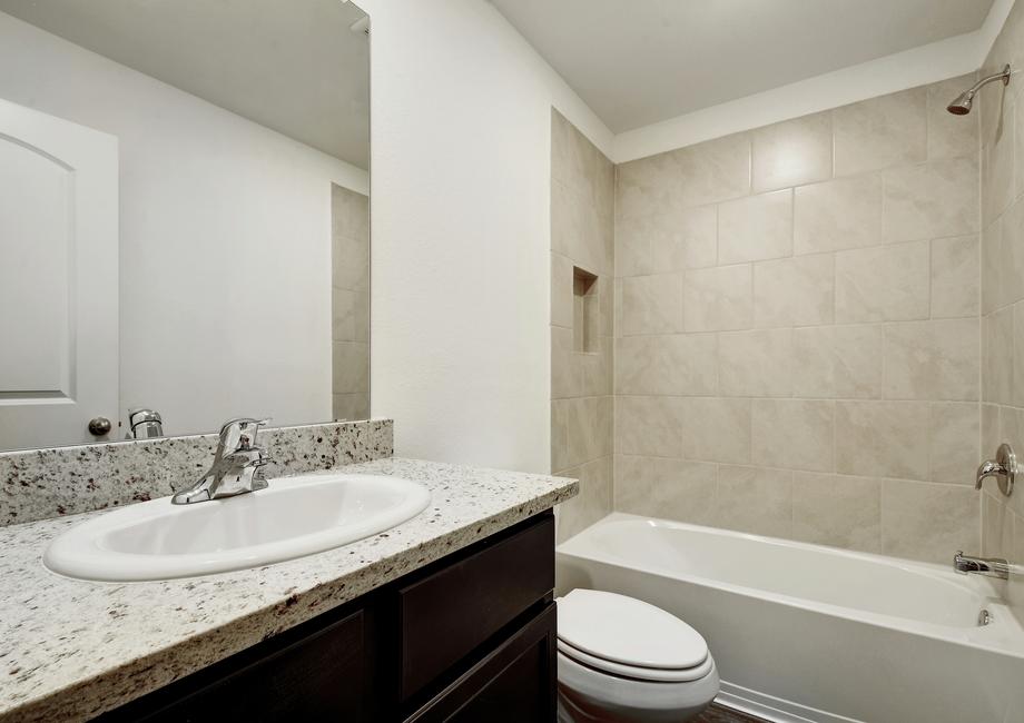 Secondary bathroom with a dual shower and bath tub and single-sink vanity.