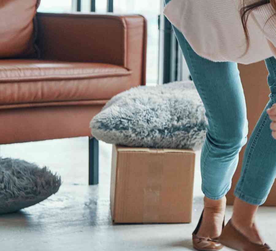 Stock photo of a cheerful young family smiling and unboxing their stuff while moving into a new home.