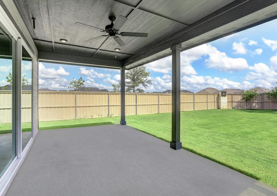 Large sliding doors lead to the covered back patio, complete with a ceiling fan.