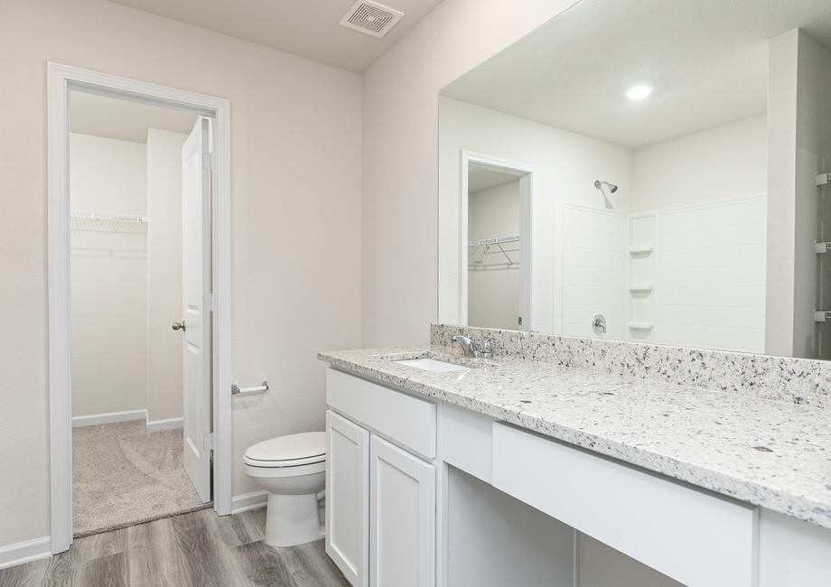 The attached master bathroom includes an expansive vanity