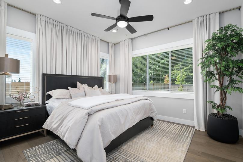 The master bedroom has lots of windows that flood the room with natural light.