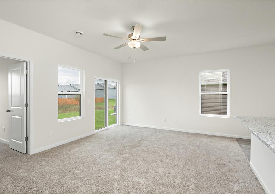 The living room has a ceiling fan and carpet.