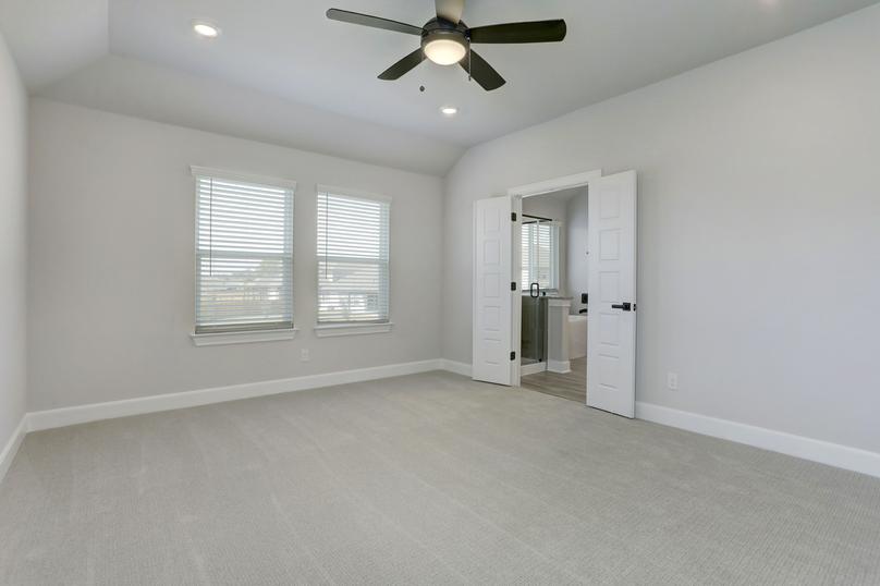 Spacious master bedroom with large windows and a connected bathroom.