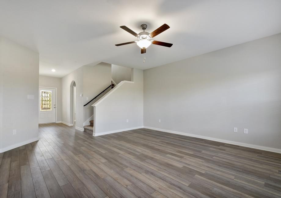 Spacious living room with a ceiling fan, connected to the foyer.