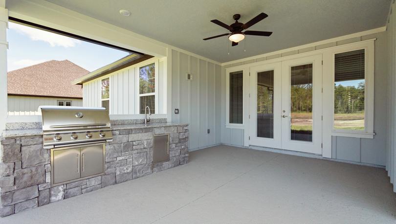 Covered outdoor kitchen with fan and built-in grill.