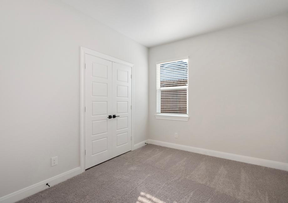 Guest bedroom with a window and recessed lighting, creating a bright space.