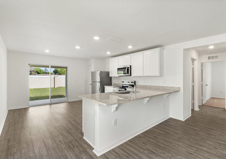 A chef-ready kitchen with a sliding door that leads to the covered patio