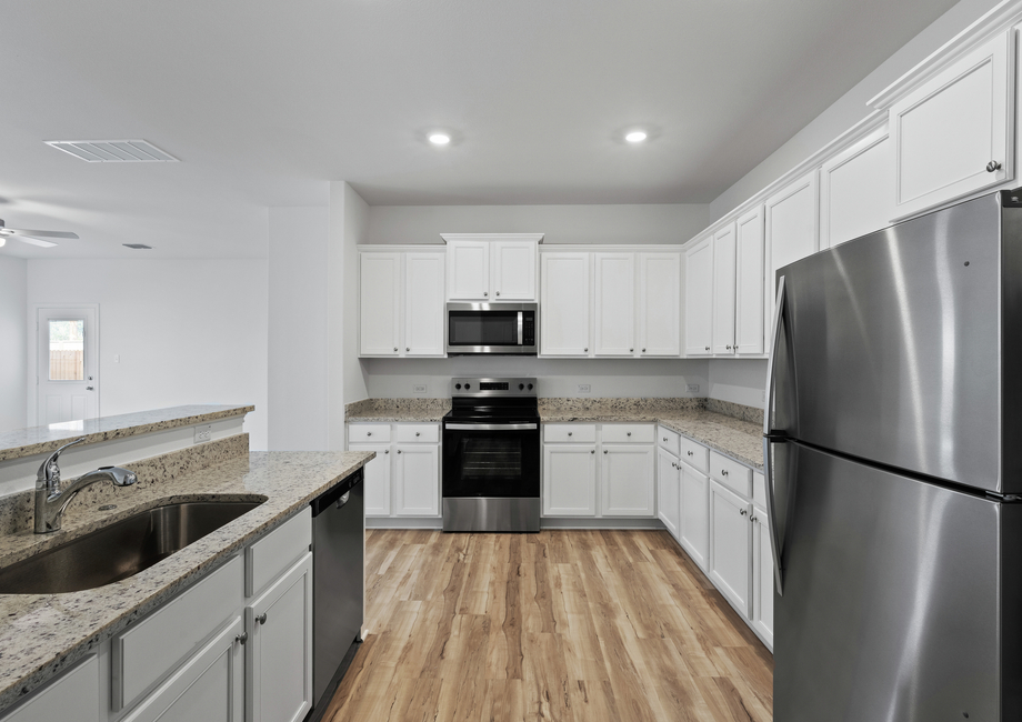 Granite countertops and stainless steel appliances are found in the kitchen