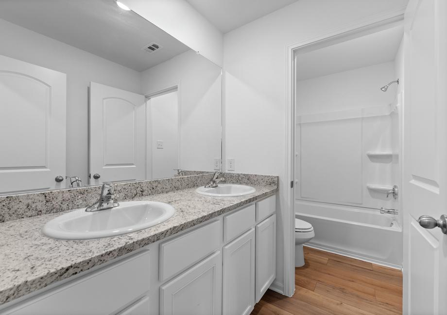 A secondary bathroom with two sinks