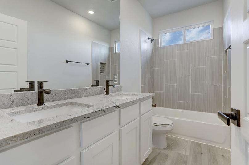 Guest bathroom with two sinks and a dual shower and tub.