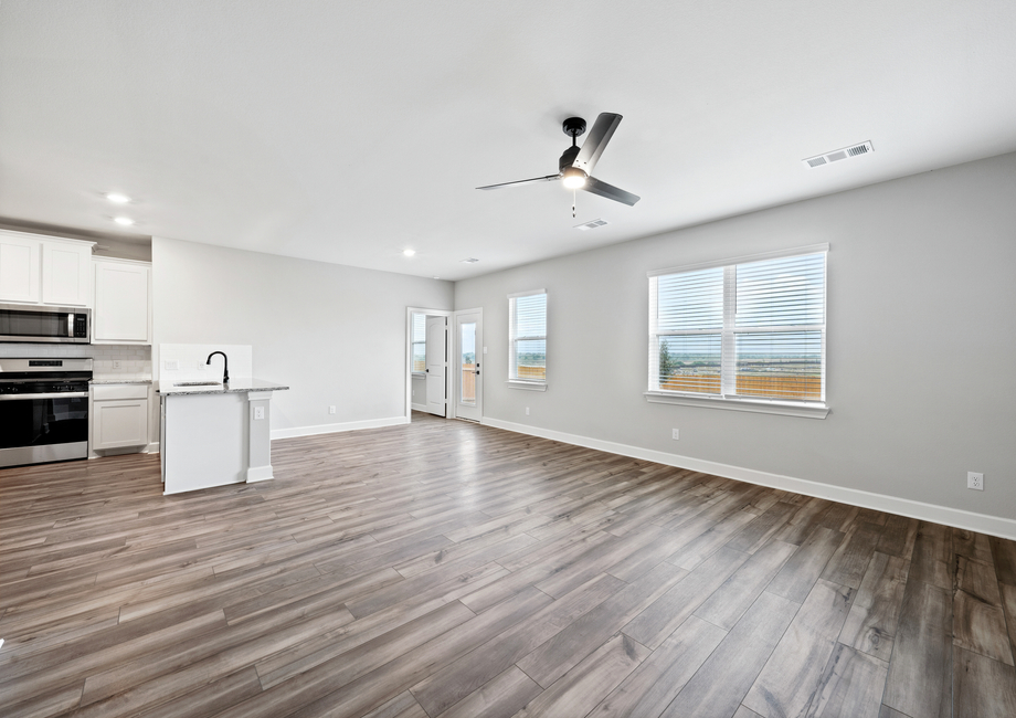 The large family room has large windows and a view of the back yard.