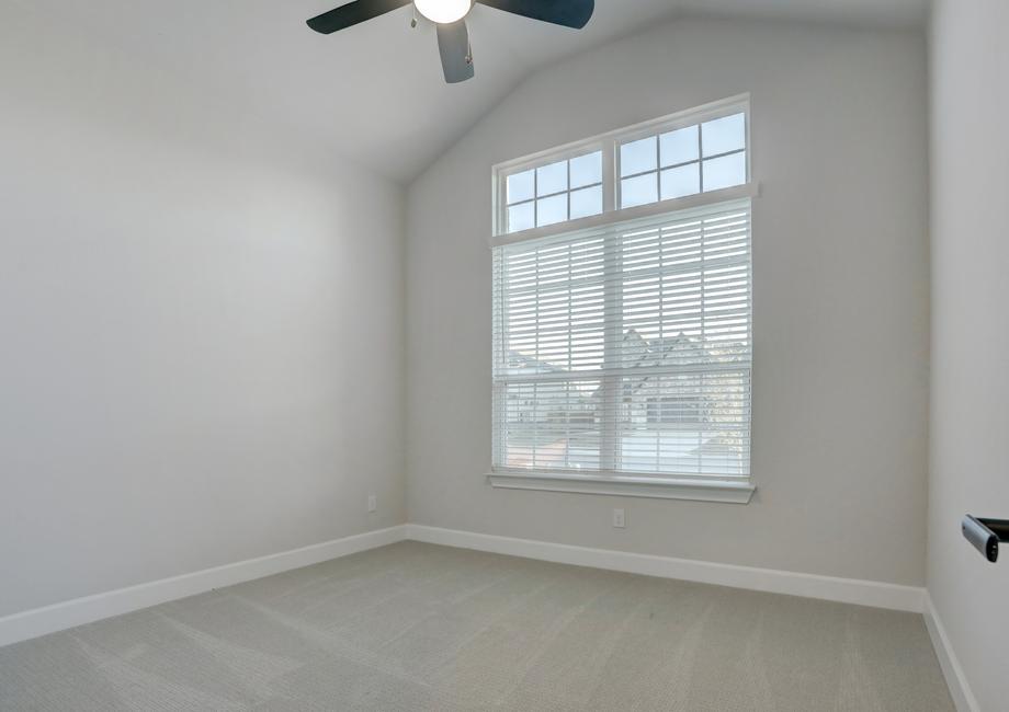 Guest bedroom with large windows, allowing natural light to flow in.