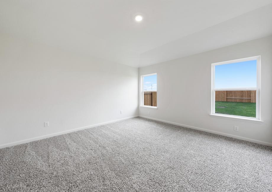 The large master bedroom has windows with great natural light and backyard views.