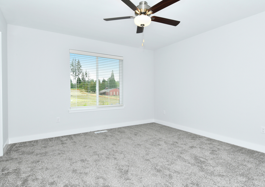 The master bedroom has carpet and a ceiling fan.