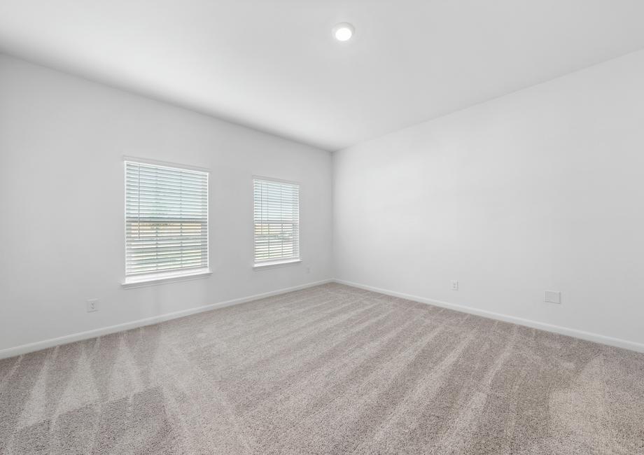 A spacious master bedroom with two windows