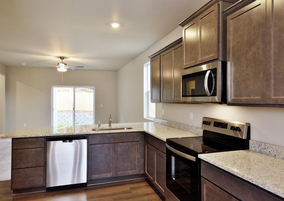 The kitchen has stainless steel appliances and plank flooring.