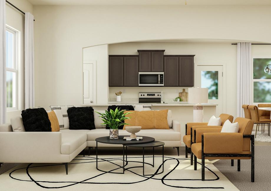 Rendering of the open floor plan's living
  area featuring large furniture and natural dÃ©cor with a view of the kitchen
  in the background.