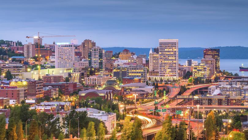 Tacoma, Washington at night with streaking lights on the freeway and lit windows on office buildings