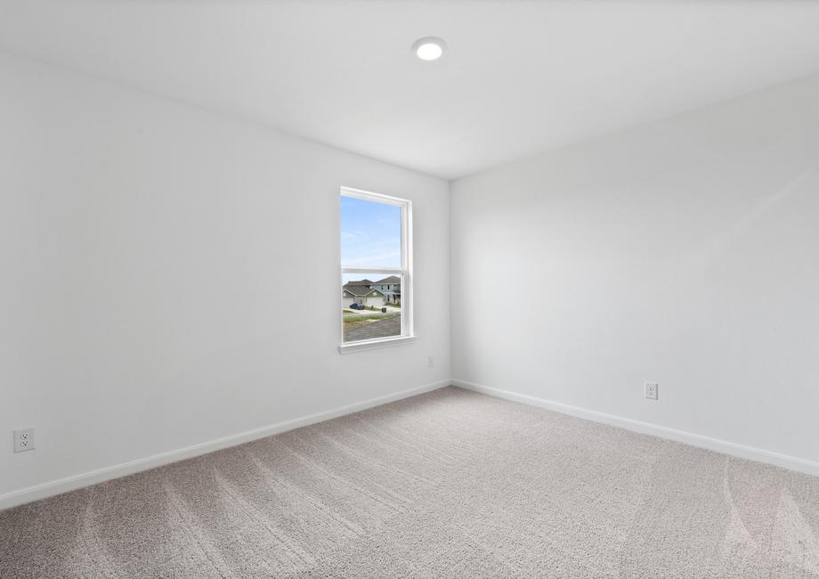 Secondary bedroom with a window and recessed lighting.