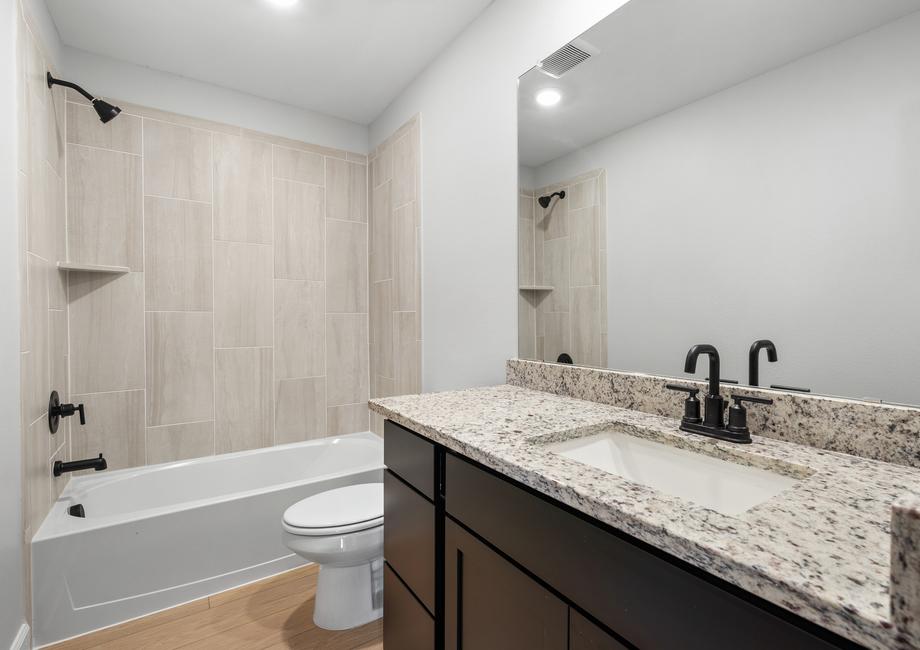 The secondary bathroom in the Piper has a large vanity and tiled shower-tub combo.