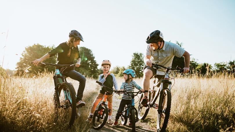 Family riding bikes on trail.