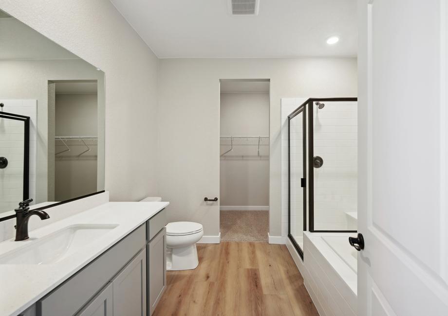The master bathroom of the Arapho has a spacious counter, walk-in glass shower and garden tub.