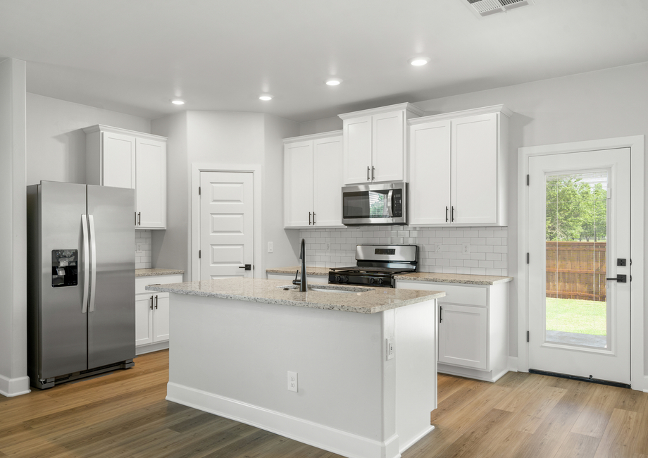 The upgraded kitchen has gorgeous white wood cabinetry.