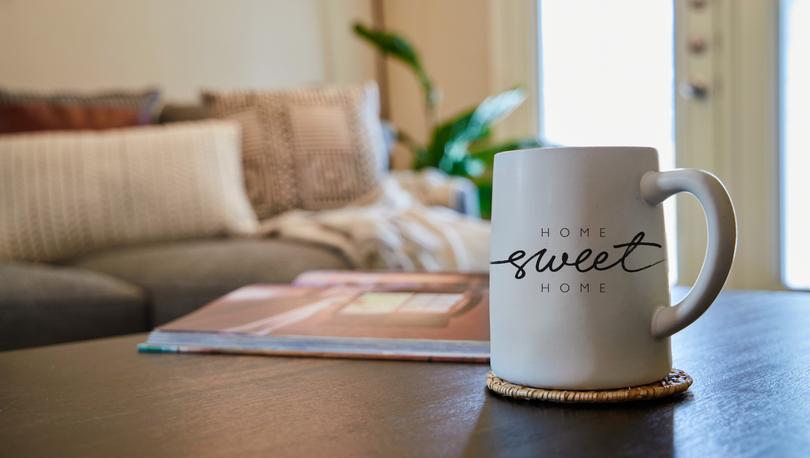 Mug with "Home Sweet Home" text on it on a table in a living room