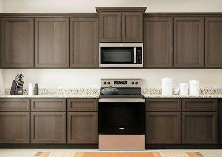 Rendering of the
  spacious kitchen in the Driftwood, which has beautiful brown cabinetry, long
  granite countertops and stainless steel appliances.