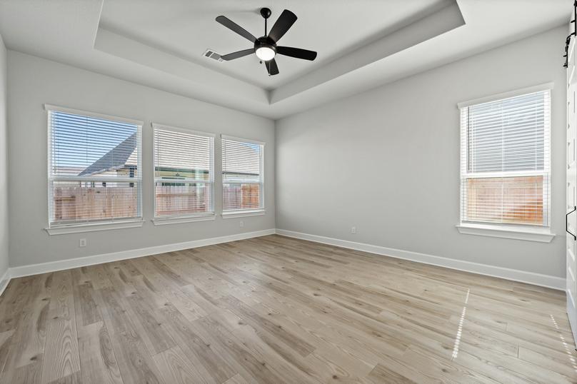 The master bedroom has plenty of natural light thanks to multiple large windows.