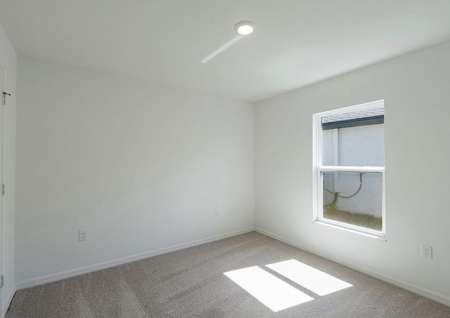 Spare bedroom with carpeted flooring and a window that lets in plenty of natural light.