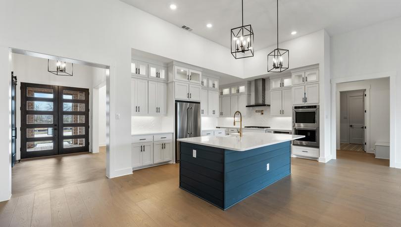 The kitchen has gorgeous white cabinetry with black hardware.