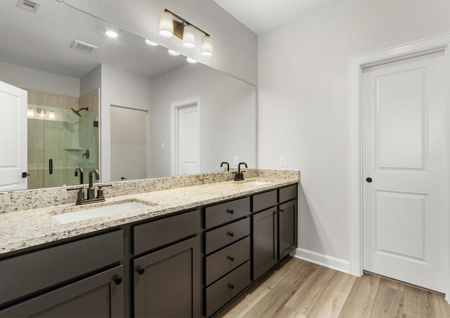 A large vanity with tons of cabinet space is found in the master bathroom