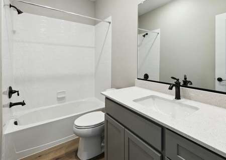 The secondary bathroom of the Chatfield plan has beautiful countertops and a great shower-tub combo.