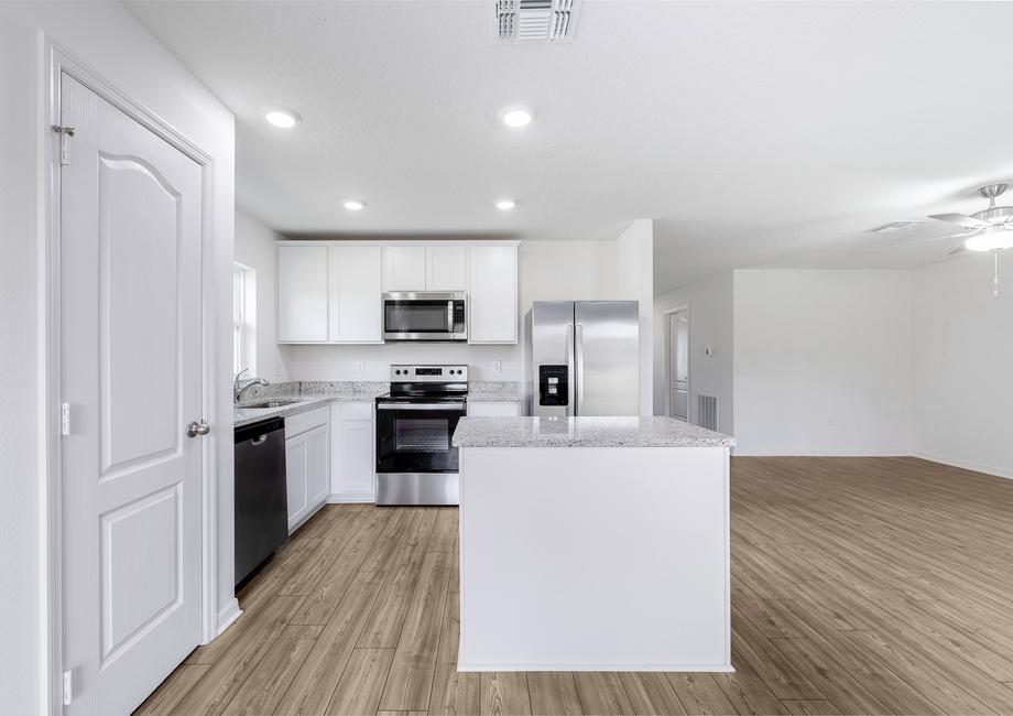 The kitchen has all white cabinets and grey granite countertops.