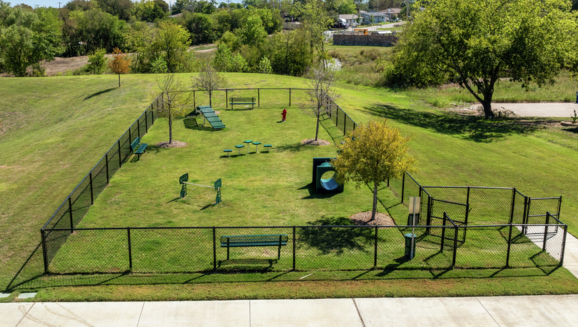 The wonderful dog park is fully fenced in and has plenty of grass and obstacles.