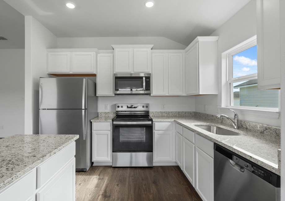 Granite countertops and stainless steel appliances fill the kitchen